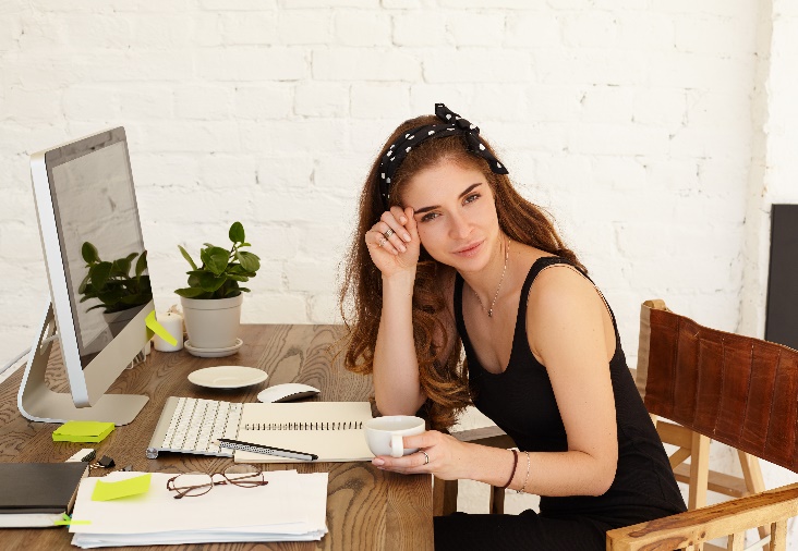 Mujer sentada en un escritorio Descripción generada automáticamente